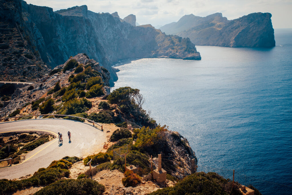 couple of cyclist on the road in cap de formentor. mallorca, spain
